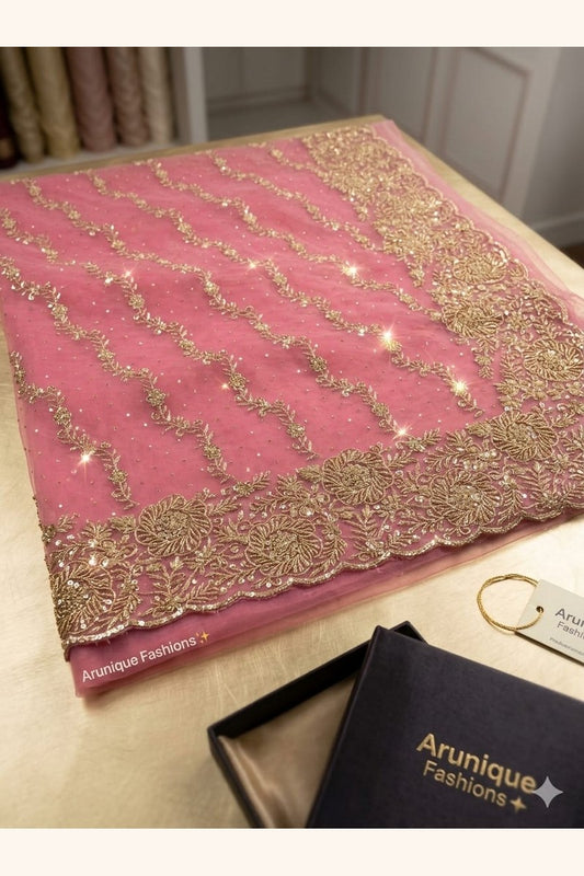 Dusty rose net saree pallu on table - diagonal gold zari floral vine embroidery and sequin butis