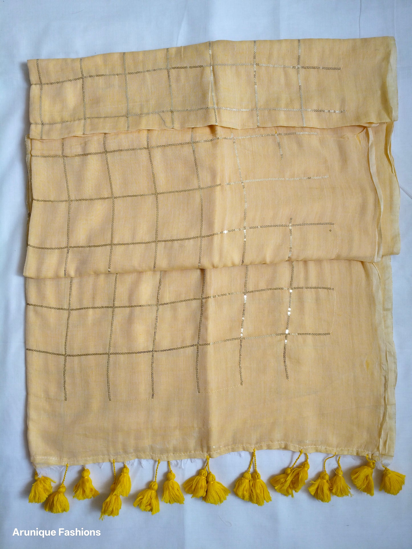 Soft pastel yellow mul cotton saree with sequin grid work - full pallu view with hand-tied yellow tassels