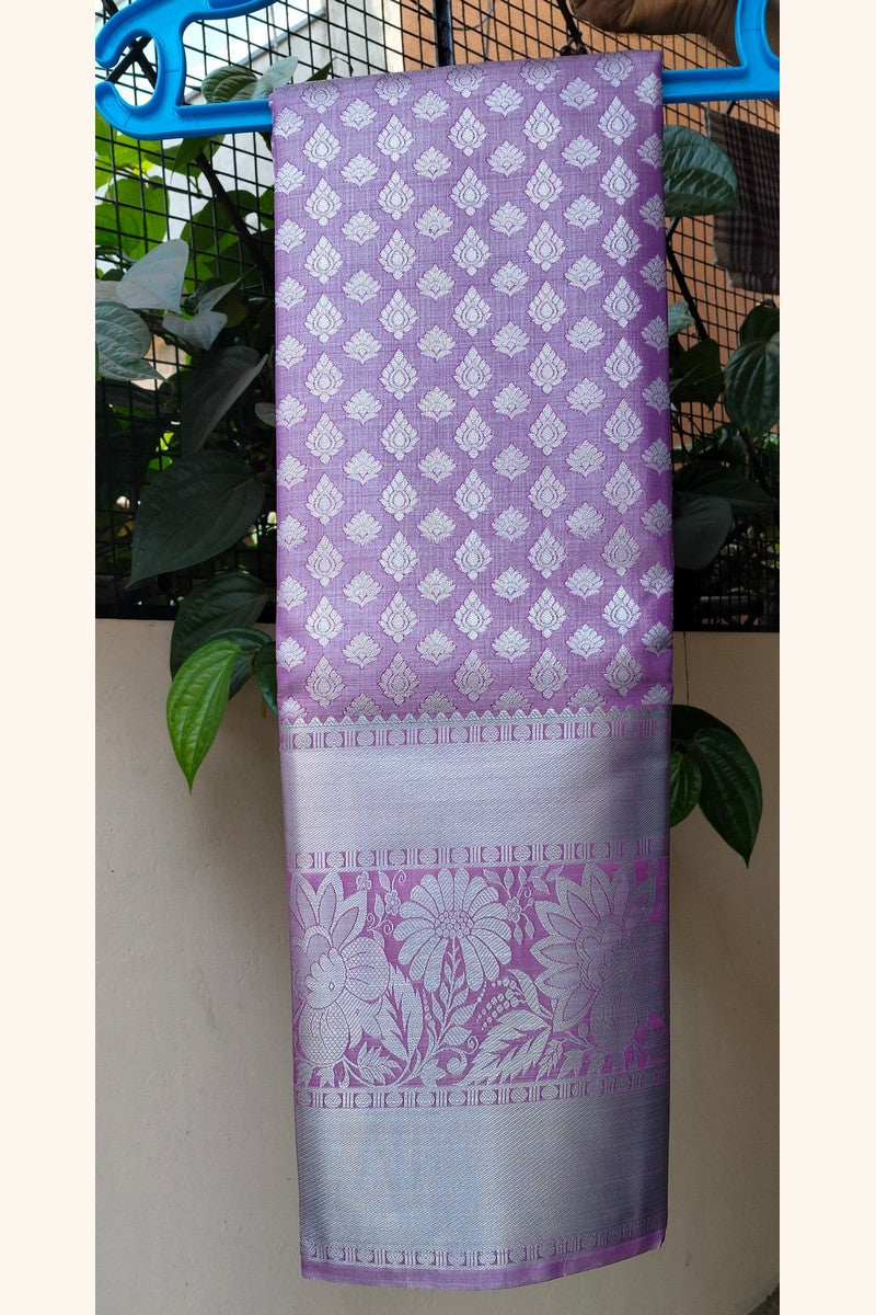 Lavender brocade saree on hanger showing wide silver tissue border detail
