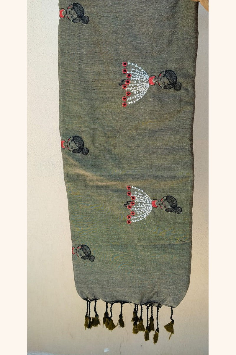 Close-up of embroidered baby doll motif fabric texture on snuff brown khadi