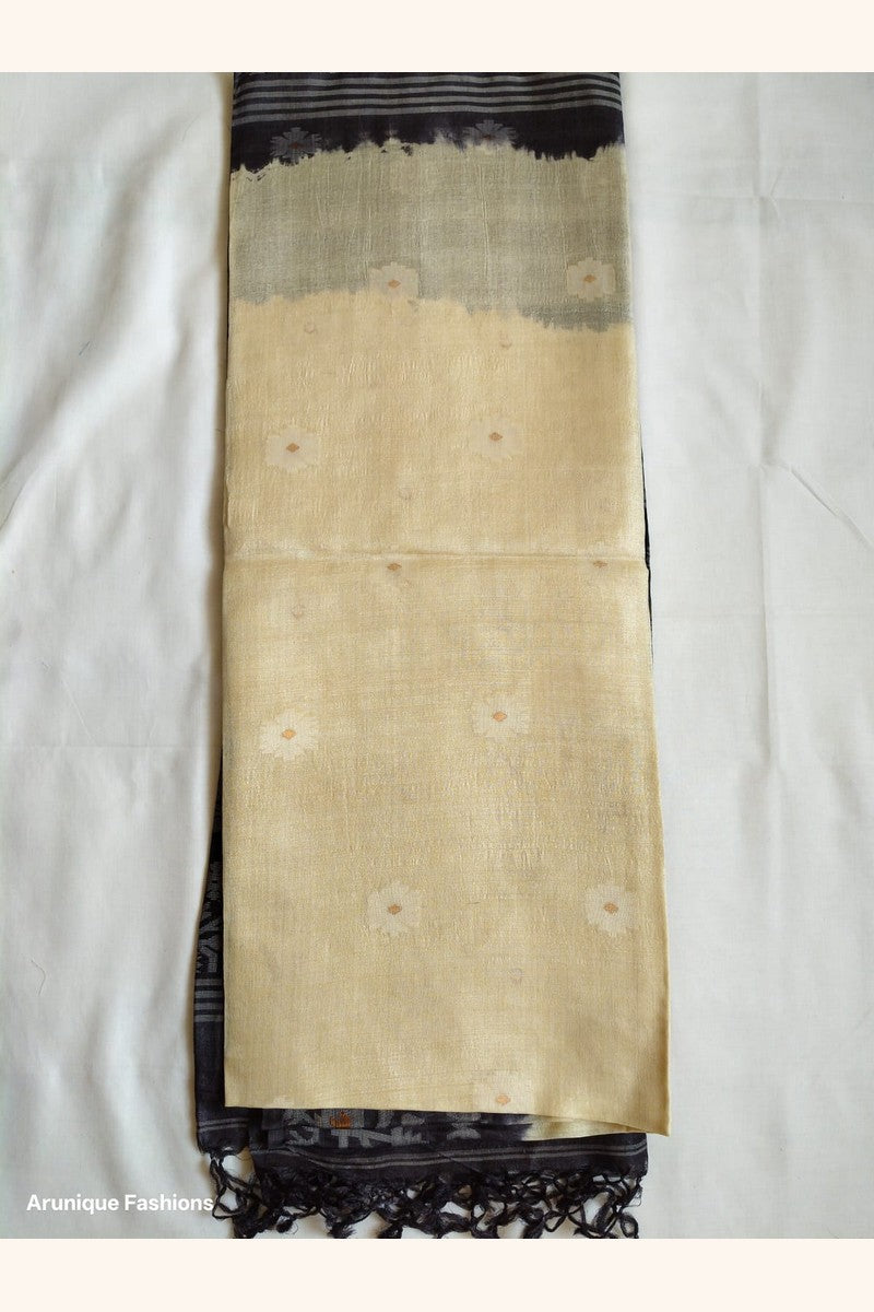 Full view of Pure Tussar Silk Saree showing cream body with scattered butti motifs and charcoal black ikat border and black tassels