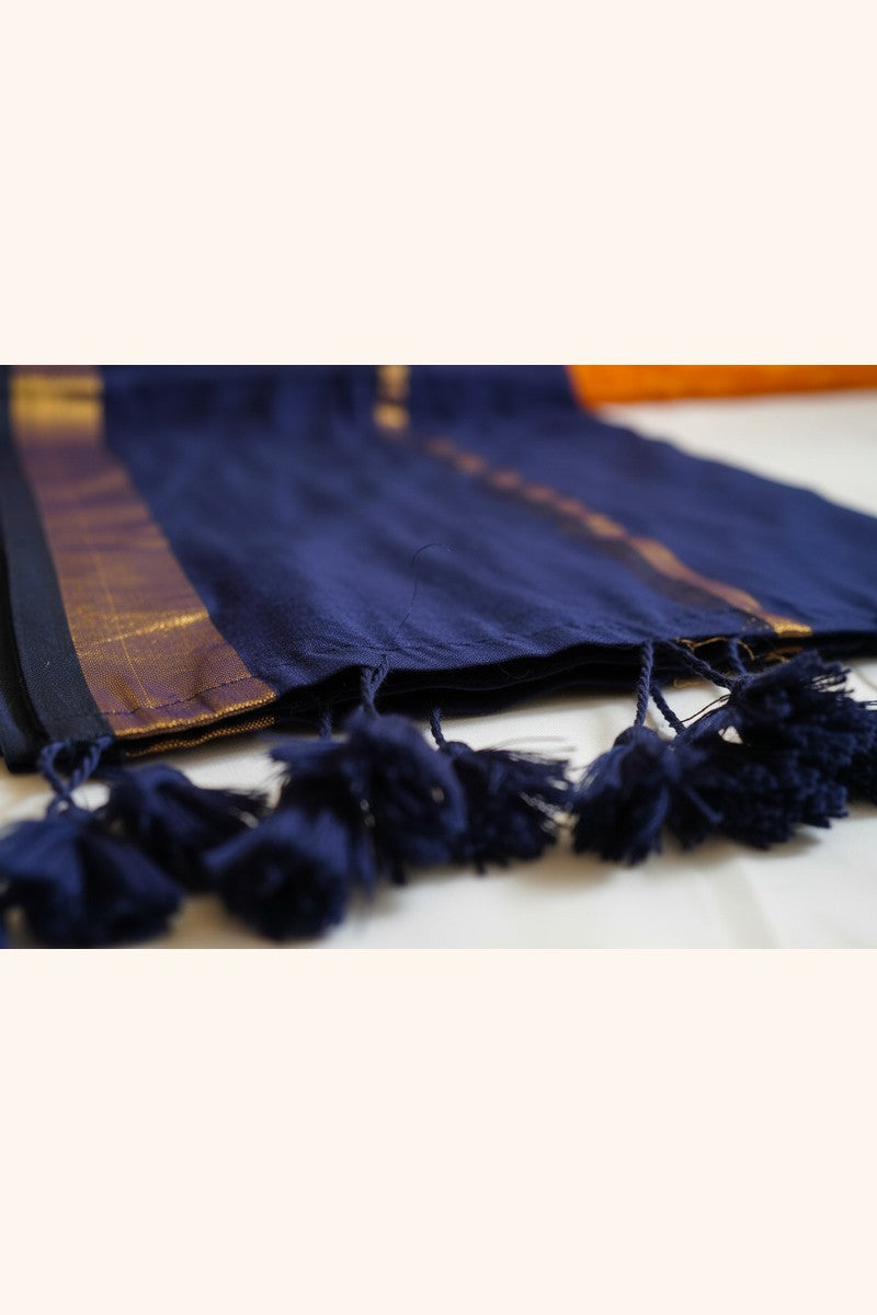 Close-up detail of navy blue mul cotton saree showing double golden zari border work and hand-tied tassels
