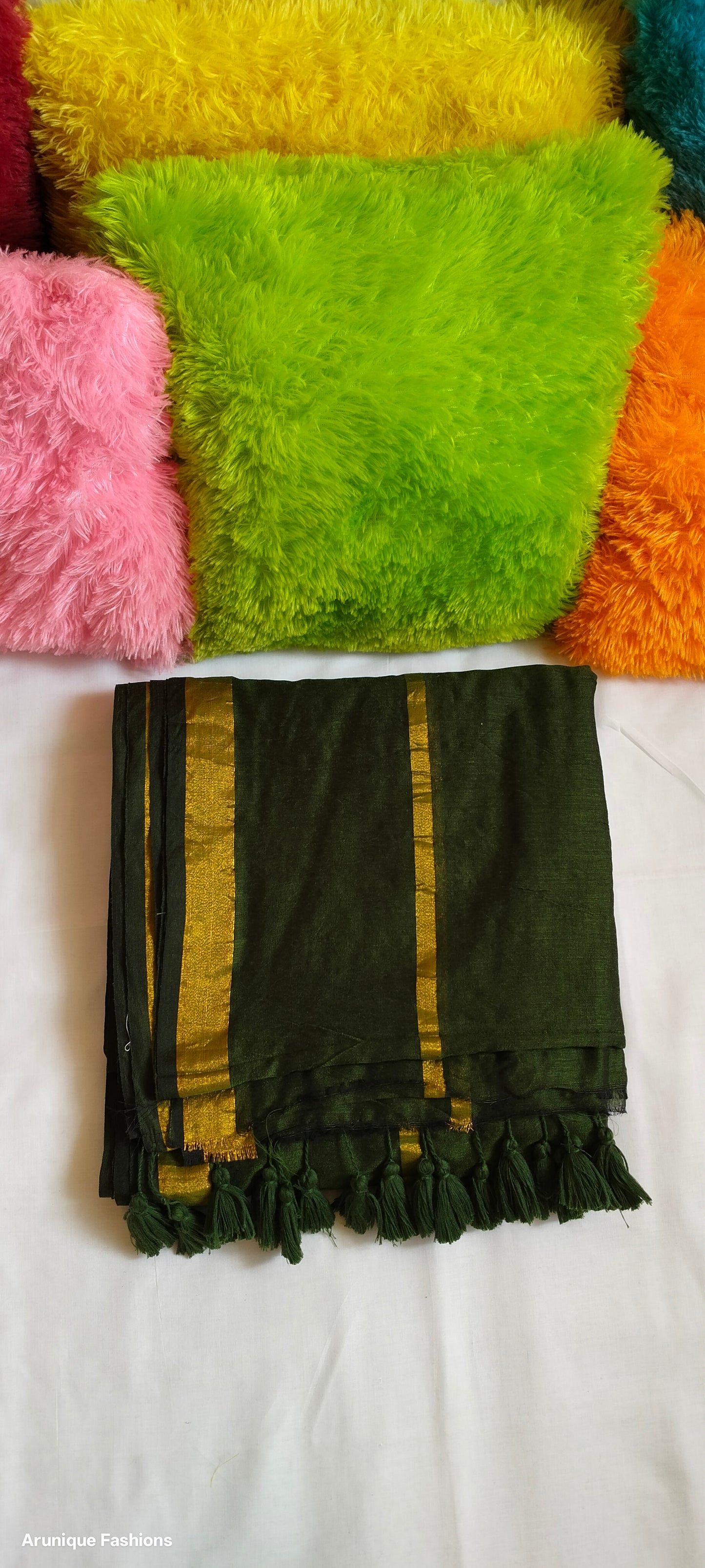 Close-up view of dark green double zari saree showing dual golden zari borders and tasseled pallu