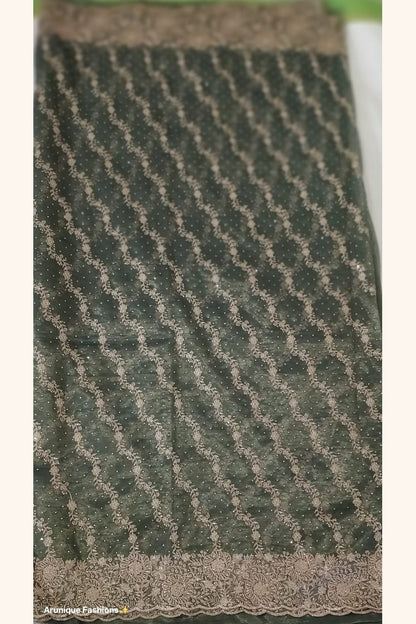 Dark olive green designer net saree - pallu with dense diagonal gold zari floral vine embroidery and stone embellishments