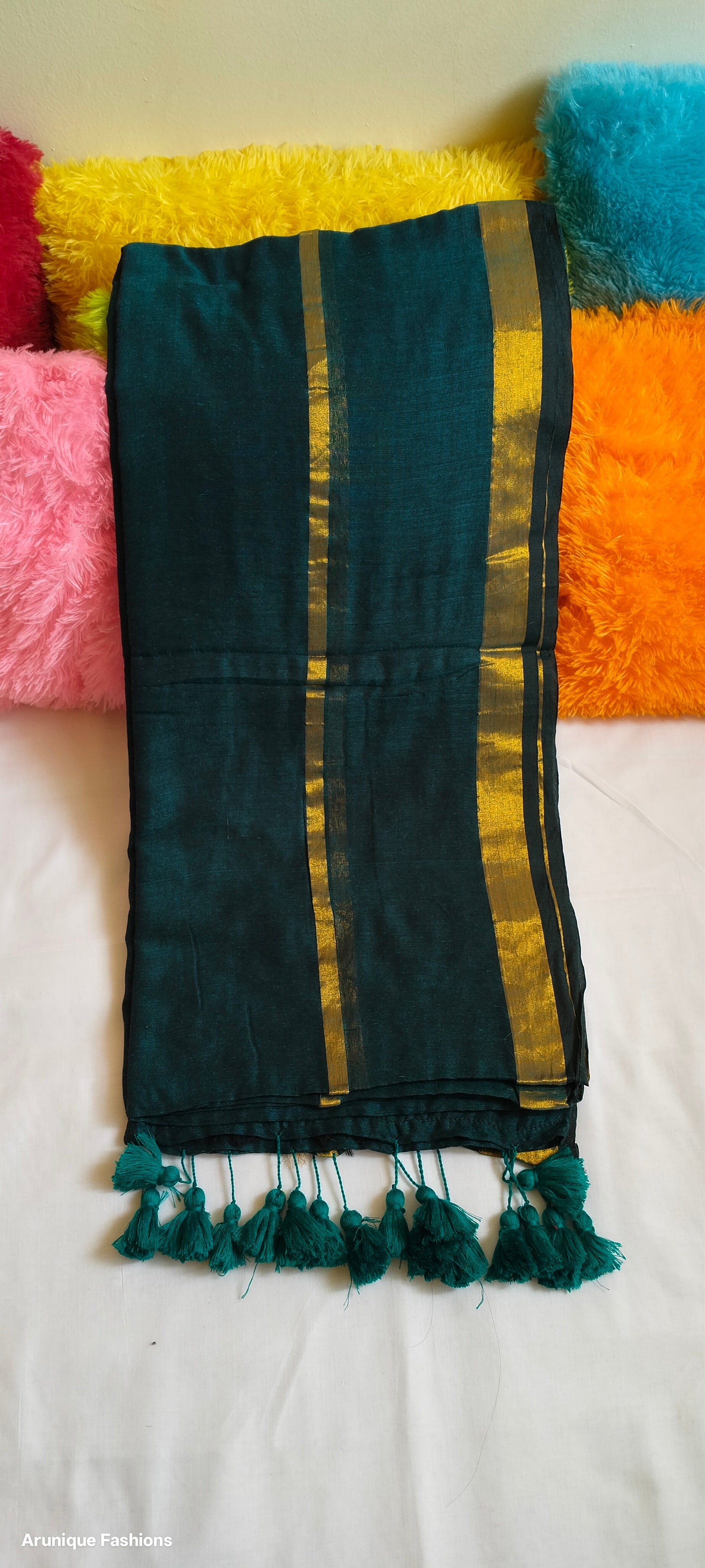 View of emerald green mul cotton saree with double golden zari borders and traditional green tassels