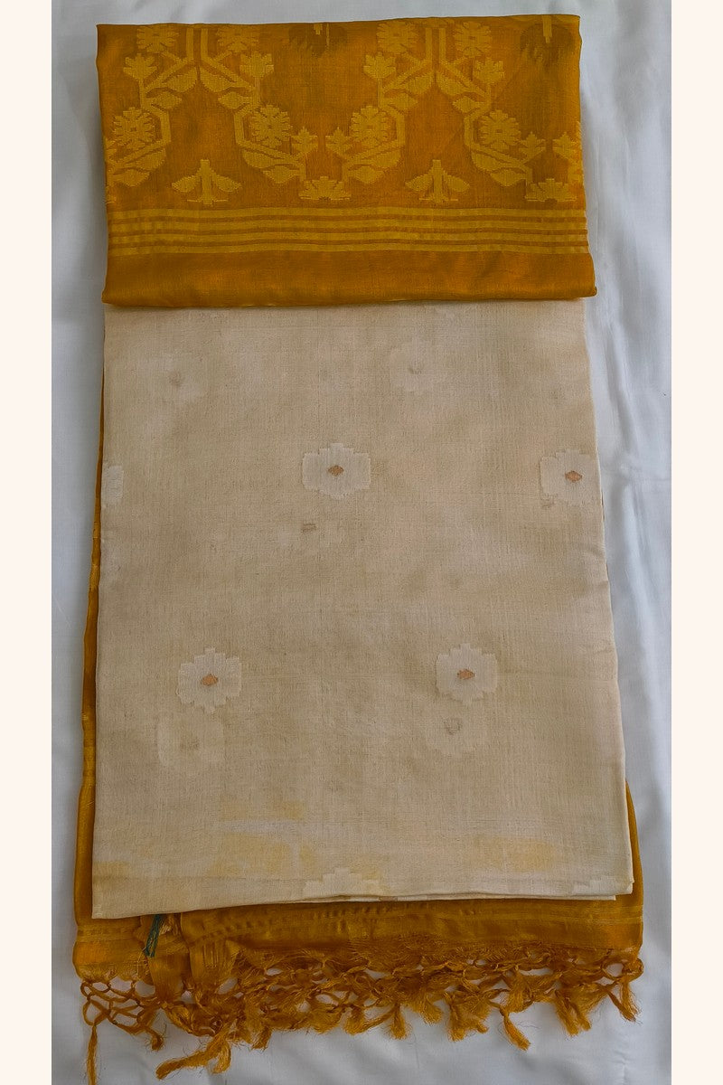 Flat lay of Pure Tussar Silk Saree showing mustard gold ikat floral pallu alongside cream body with floral butti motifs