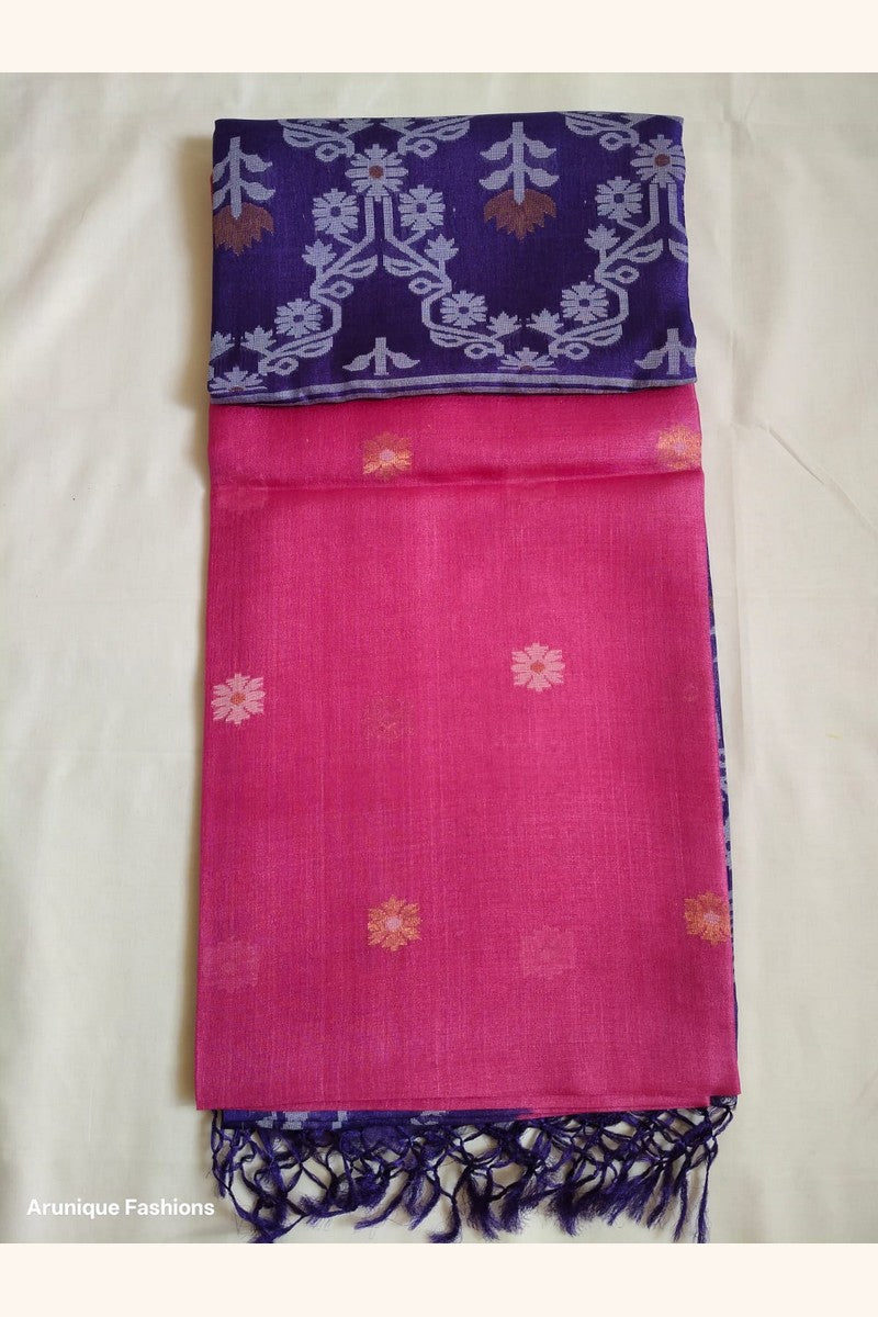 Folded Pure Tussar Silk Saree showing hot pink body with pink and orange daisy butti motifs and royal purple ikat border with navy tassels