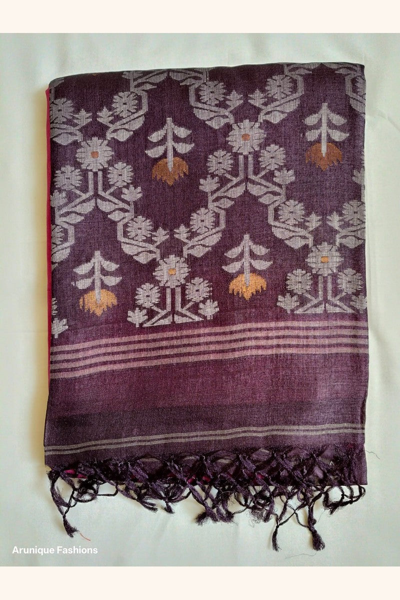 Folded Pure Tussar Silk Saree showing hot pink body with pink daisy butti motifs and deep plum ikat floral border with black tassels