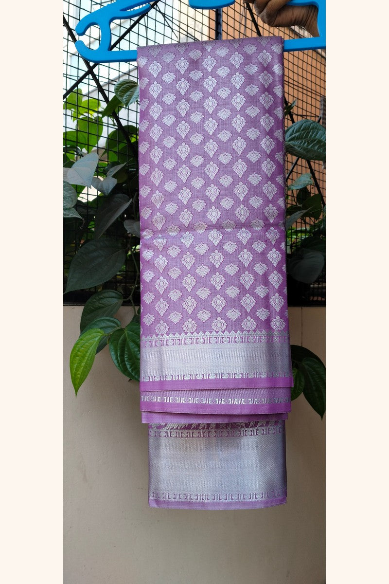 Lavender brocade saree on hanger showing short silver tissue border