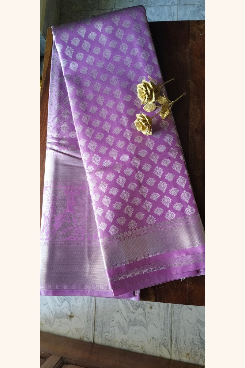 Lavender brocade semi-silk saree displayed on wooden table