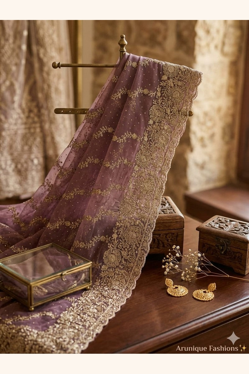 Mauve premium designer net saree - styled drape showing diagonal gold zari embroidery and scalloped border