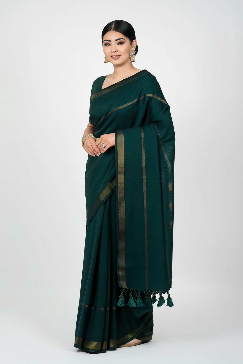 Model wearing dark green double zari mul cotton saree with dual golden borders
