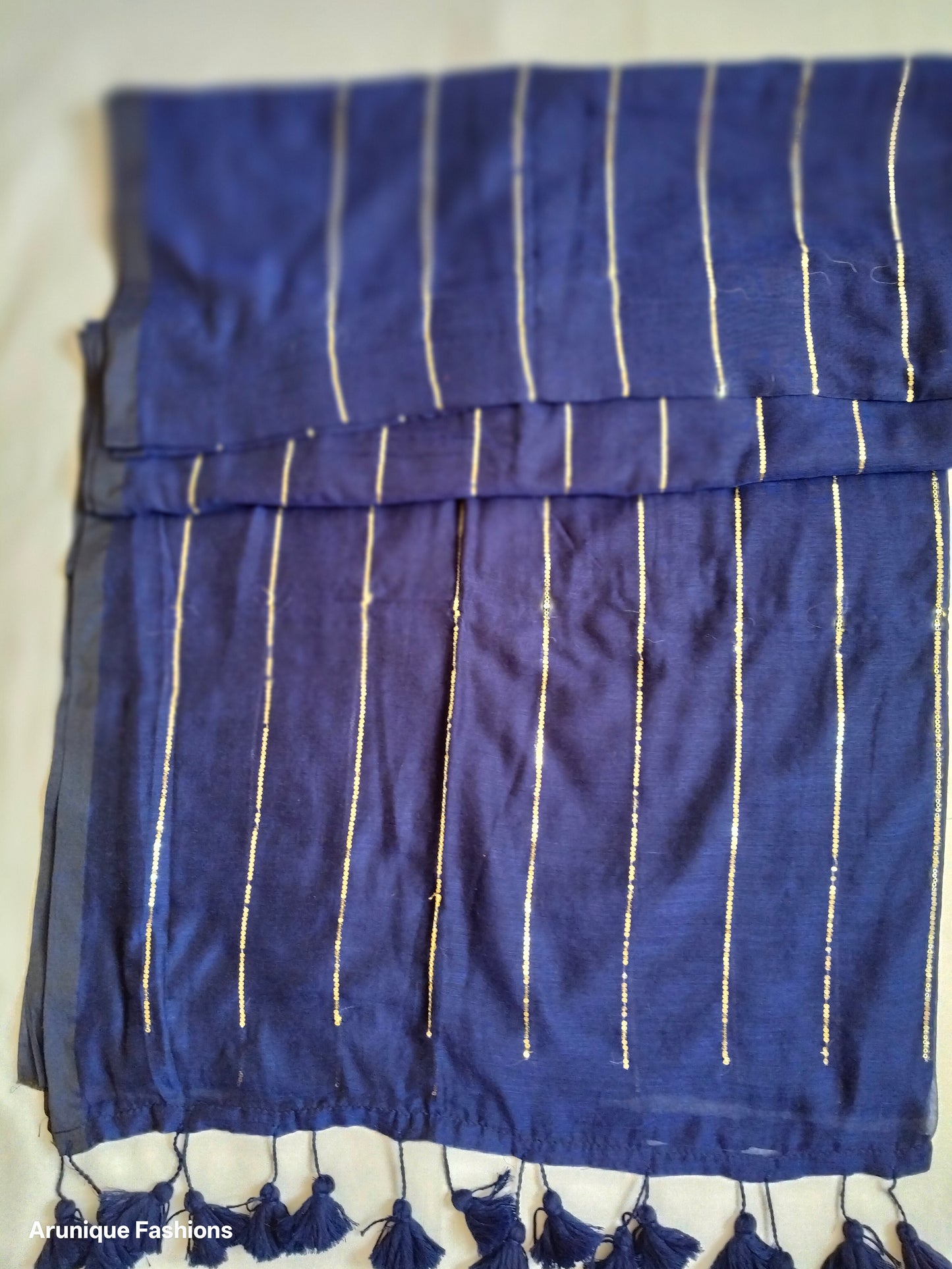 Trendy navy blue sequin mul cotton saree - folded view showing vertical sequin lines and fabric drape