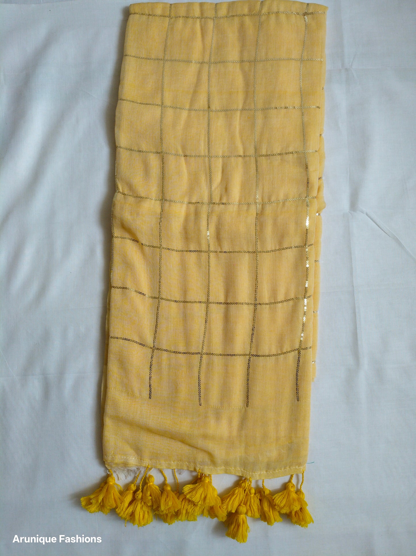Trendy soft pastel yellow sequin mul cotton saree - full view with yellow tassels and grid pattern