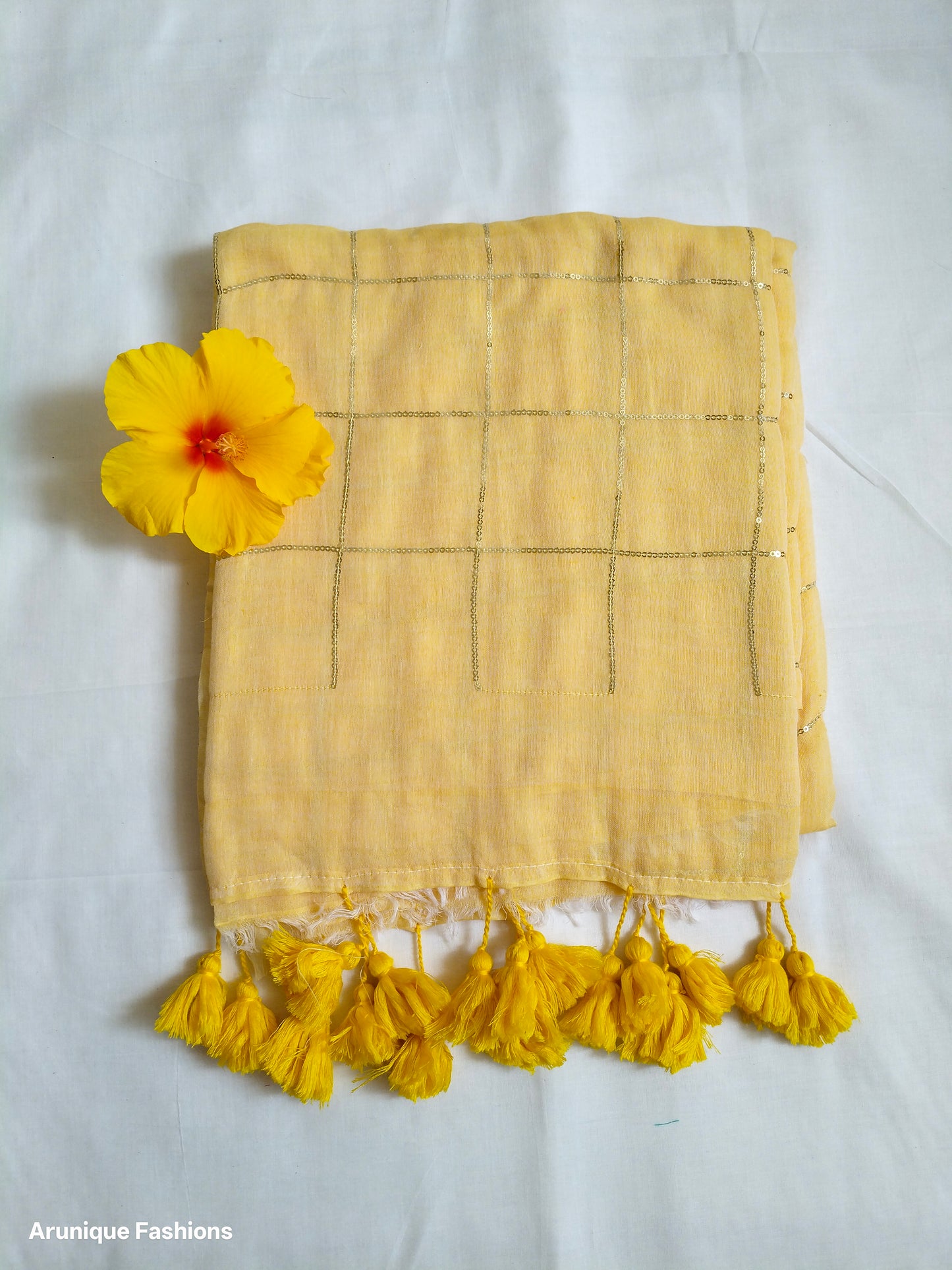 Soft pastel yellow mul cotton saree with golden sequin grid - fabric texture detail with decorative flower