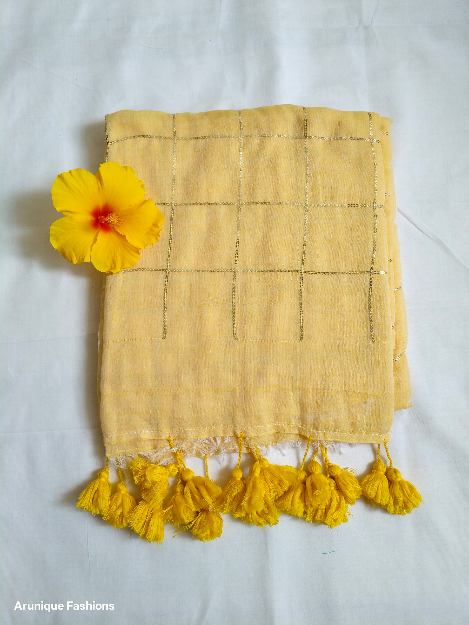 Soft pastel yellow mul cotton saree with golden sequin grid - fabric texture detail with decorative flower
