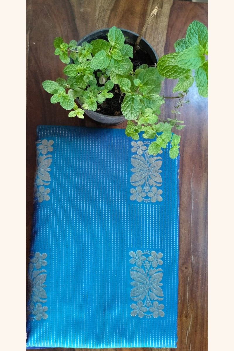 Turquoise Blue Saree with Golden Floral Butta & Purple Pink Zari Pallu - Saree Display on Table