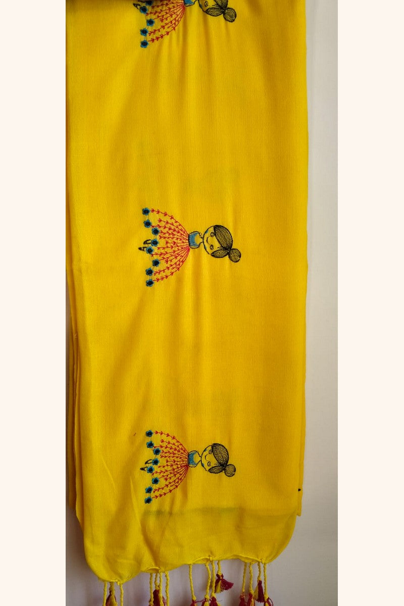 Close-up of embroidered baby doll motif fabric texture on yellow khadi